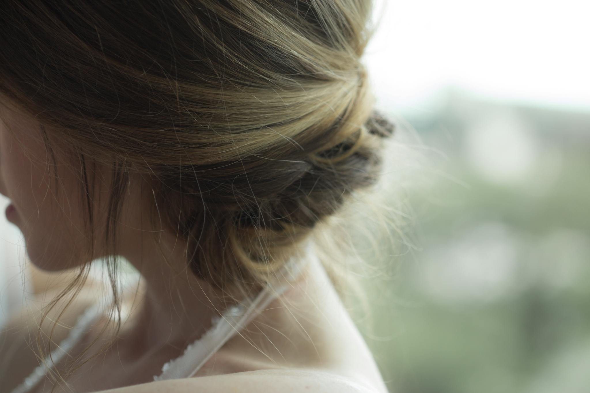 Close-up of elegant blonde updo hairstyle on a woman indoors.